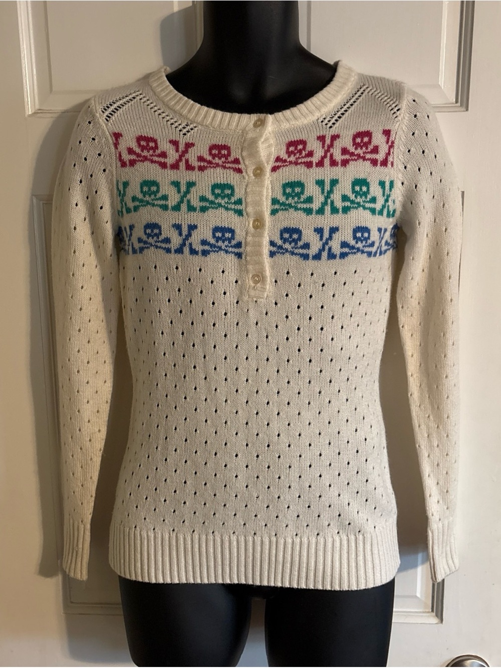 Delia’s Y2K Cream Knit Henley Sweater with Multicolor Skull Pattern